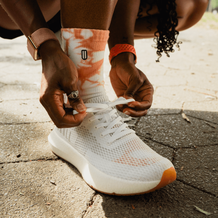 Woman tying white shoe