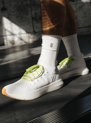 Man wearing Drive Knit shoes with green laces.