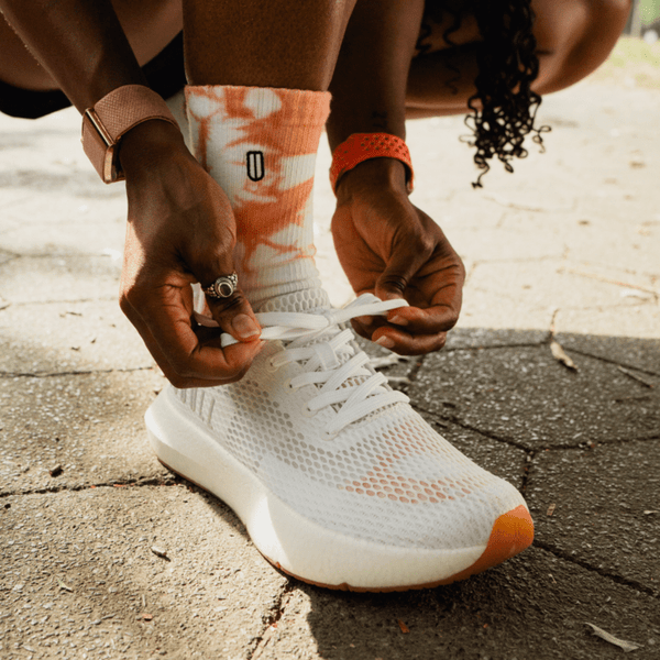 Woman tying white shoe