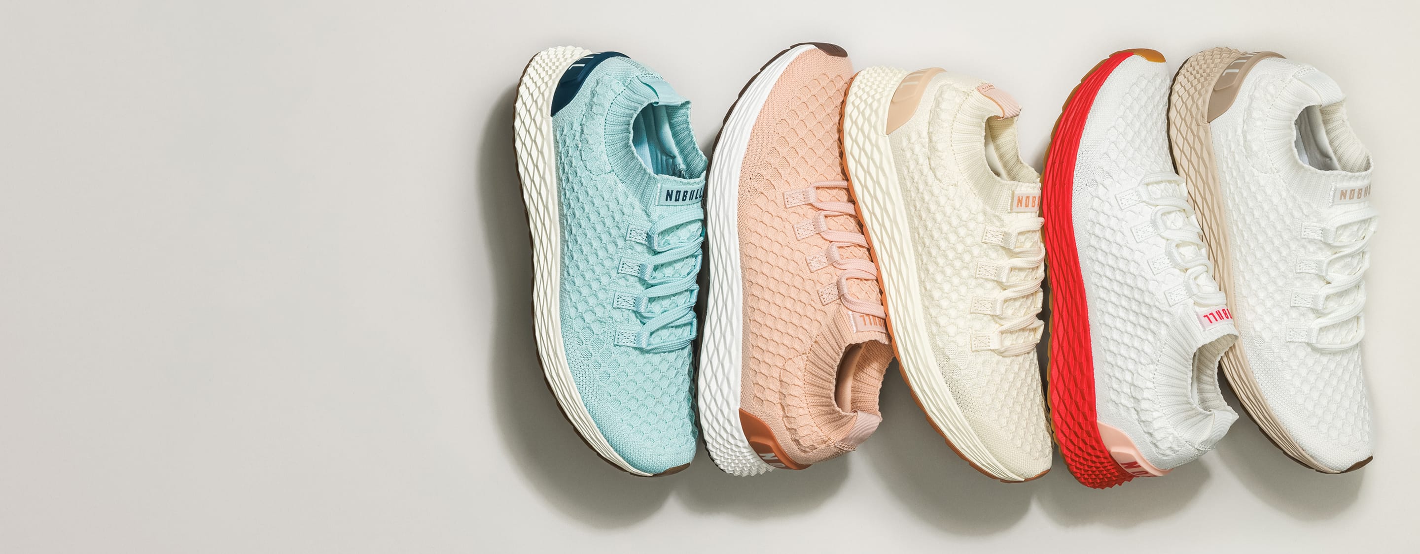 Five colorful sneakers arranged in a row on a light gray background
