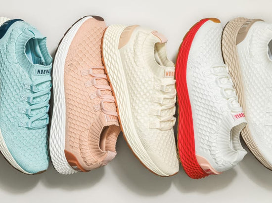 Four pairs of sneakers in different colors arranged in a row on a light background