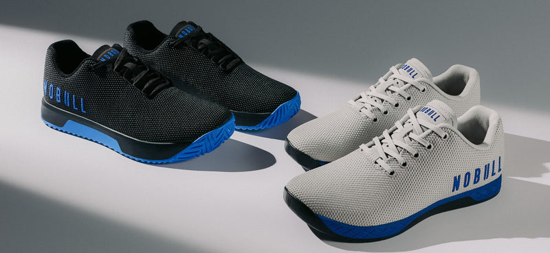 promo - Two pairs of Outworks on a gray studio background. The left pair is black with bright blue soles and blue 'NOBULL' branding.