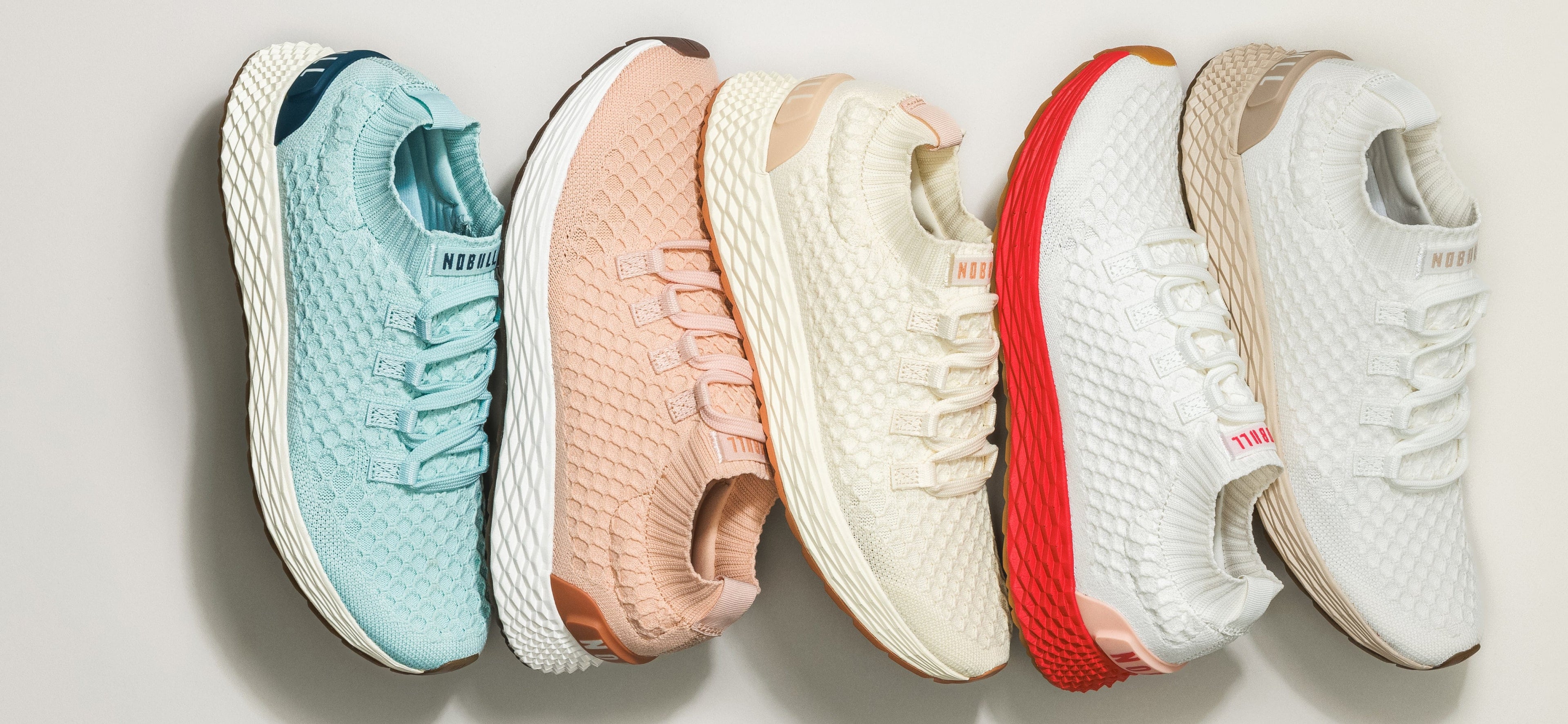 Five allday knit shoes in different colors arranged in a row.