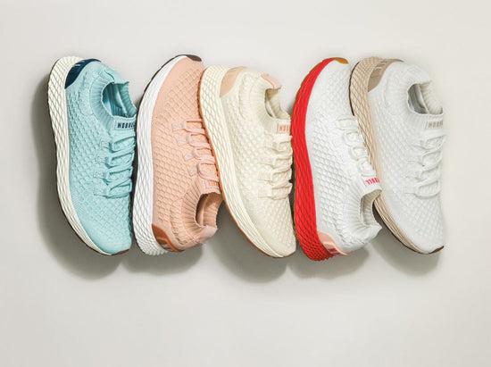Five allday knit shoes in different colors arranged in a row.