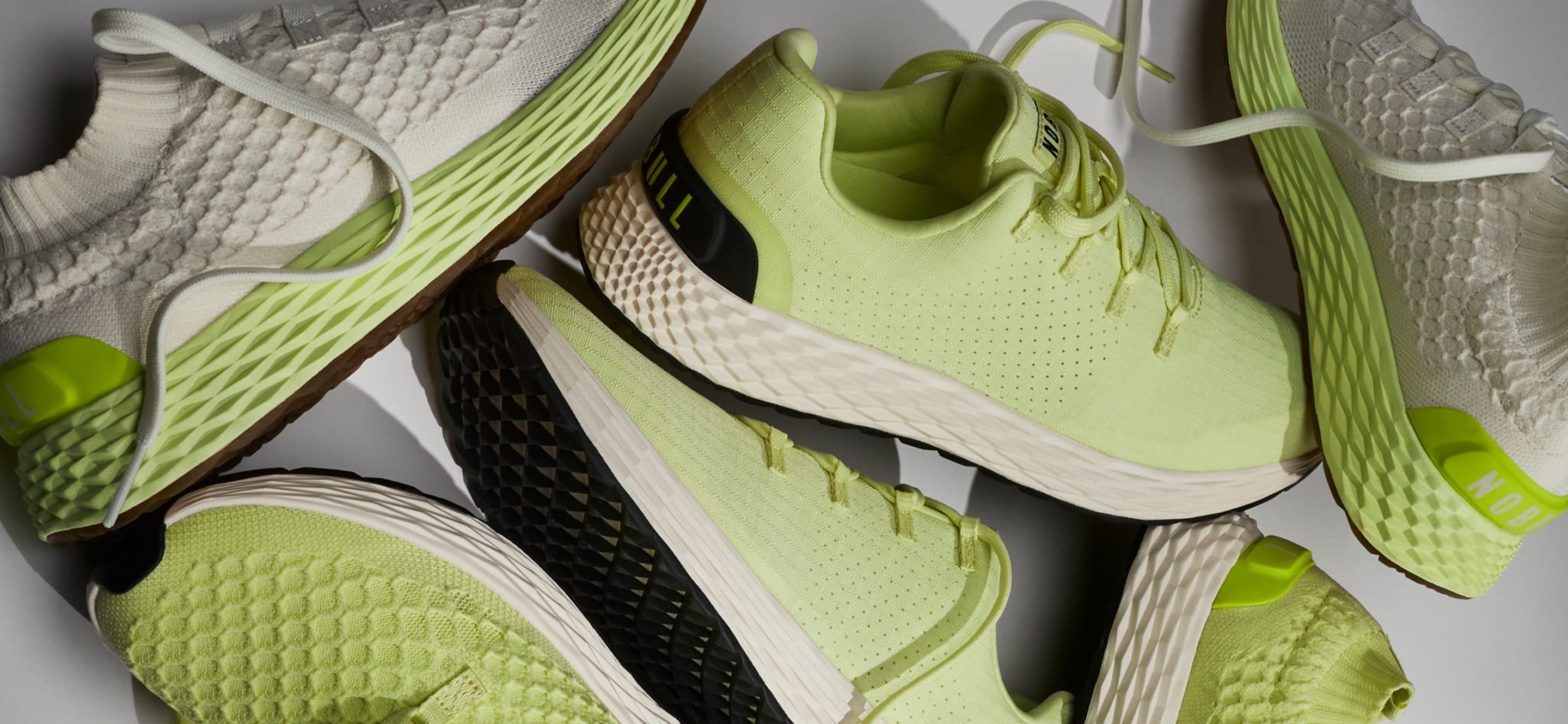 Green athletic shoes with textured soles on a light gray background