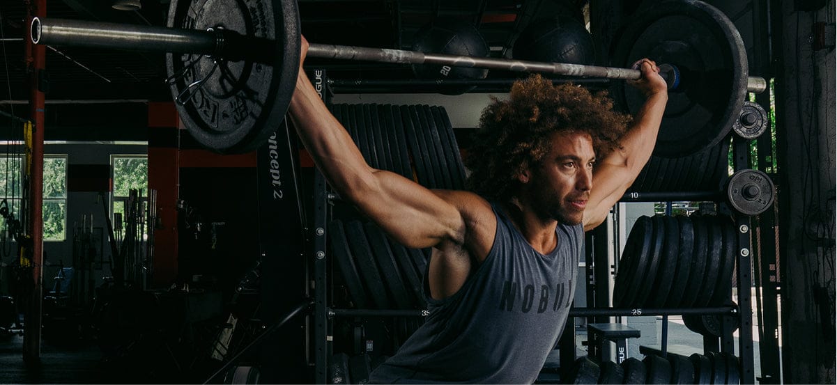 Man lifting a barbell in a gym setting