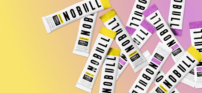 promo - Multiple NOBULL electrolyte packets on a colorful background
