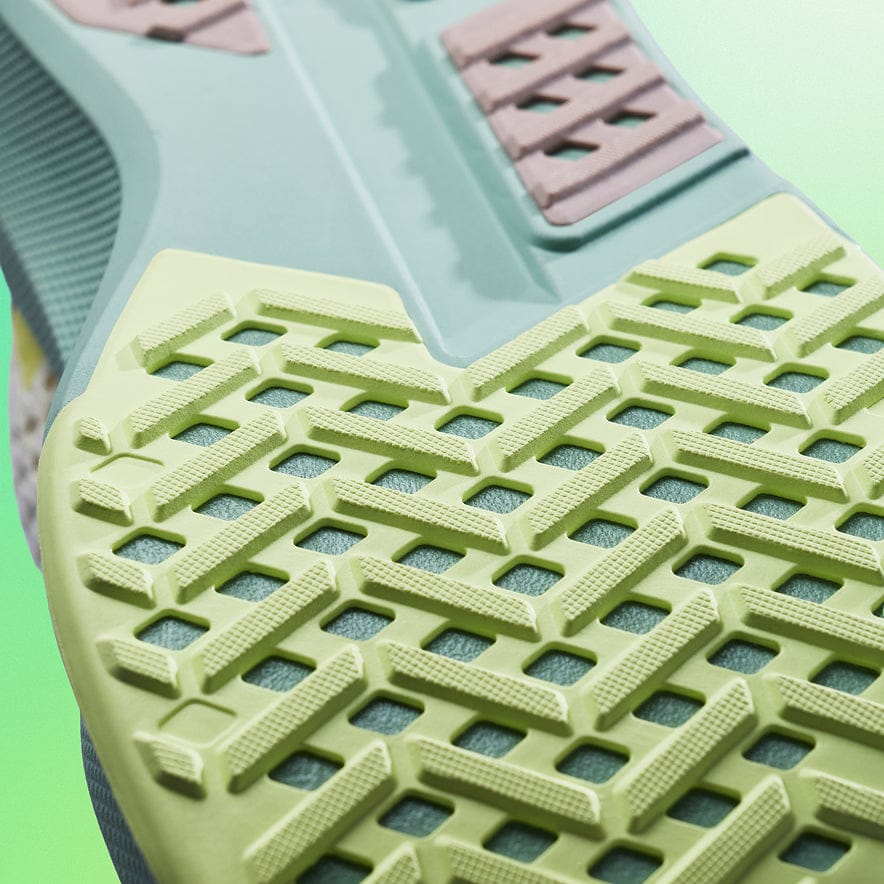 Close-up of a green and pink plastic stool with textured surface on a green background