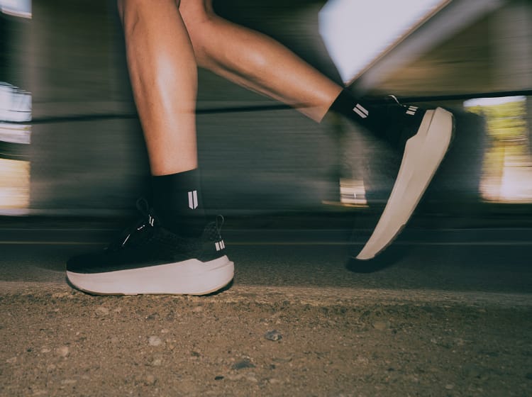 Person riding a bicycle with focus on black shoes and socks.