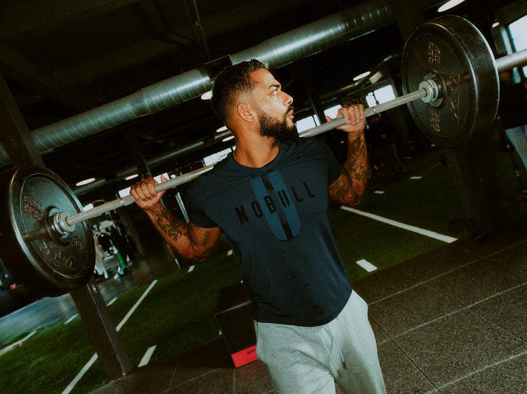 Man Wearing NOBULL U Tee Lifting Weights.