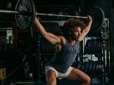 Man lifting a barbell in a gym setting