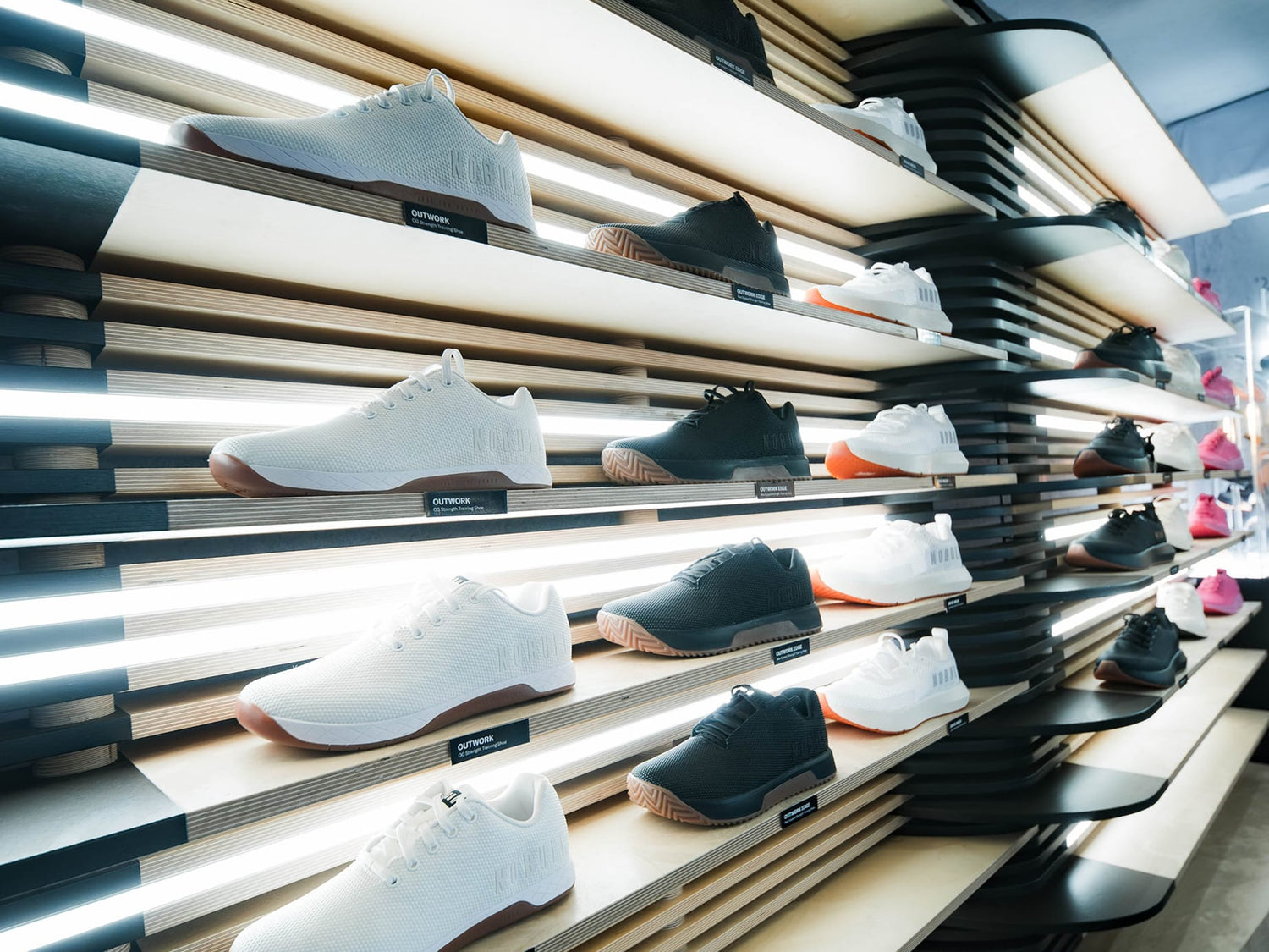 Shelves displaying a variety of shoes with a focus on white and black colors.