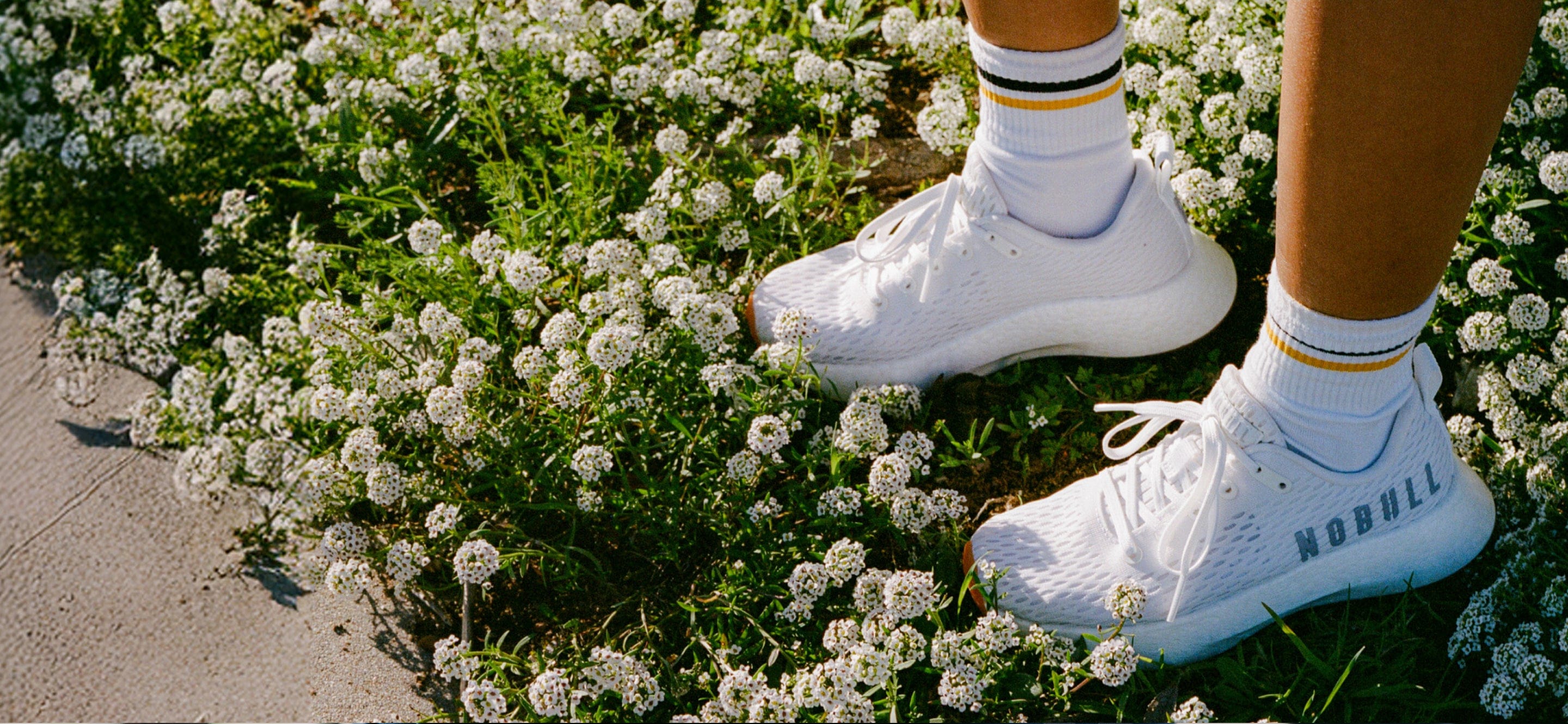 White Journeys on a person standing on a patch of white flowers.