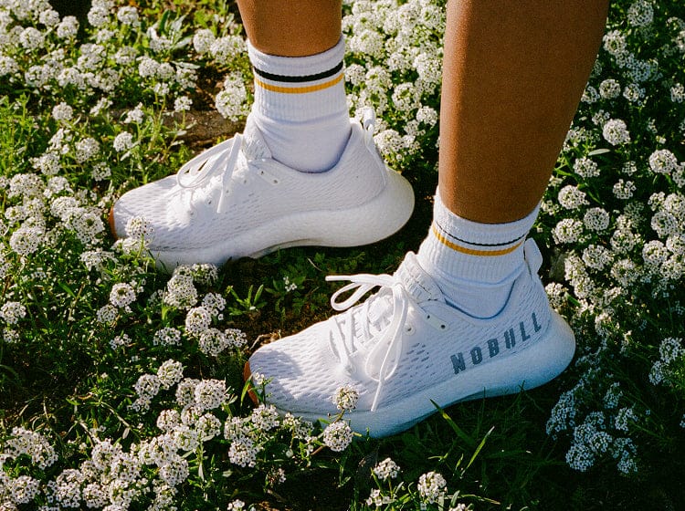White Journeys on a person standing on a patch of white flowers.