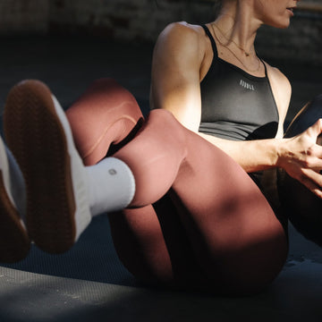 woman with a medicine ball wearing red leggings
