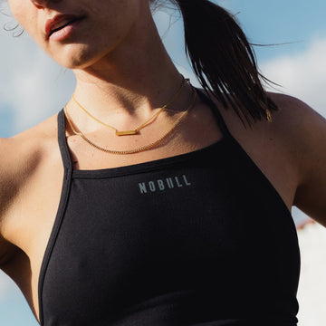 Woman wearing black NOBULL high-neck sports bra