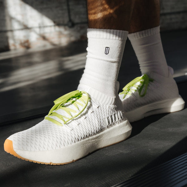 Men's White Drive Knit Shoe On Body Angle.