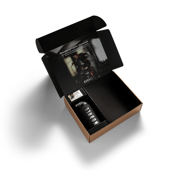 Open black box with a black tumbler and product packaging on a white background