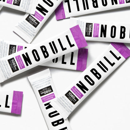 Blueberry pomegranate electrolyte sticks with purple and black accents on a white background