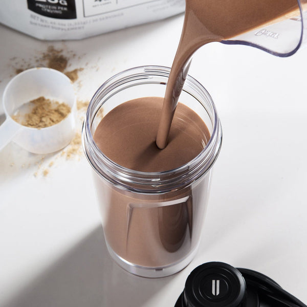 Chocolate protein shake being poured into a jar