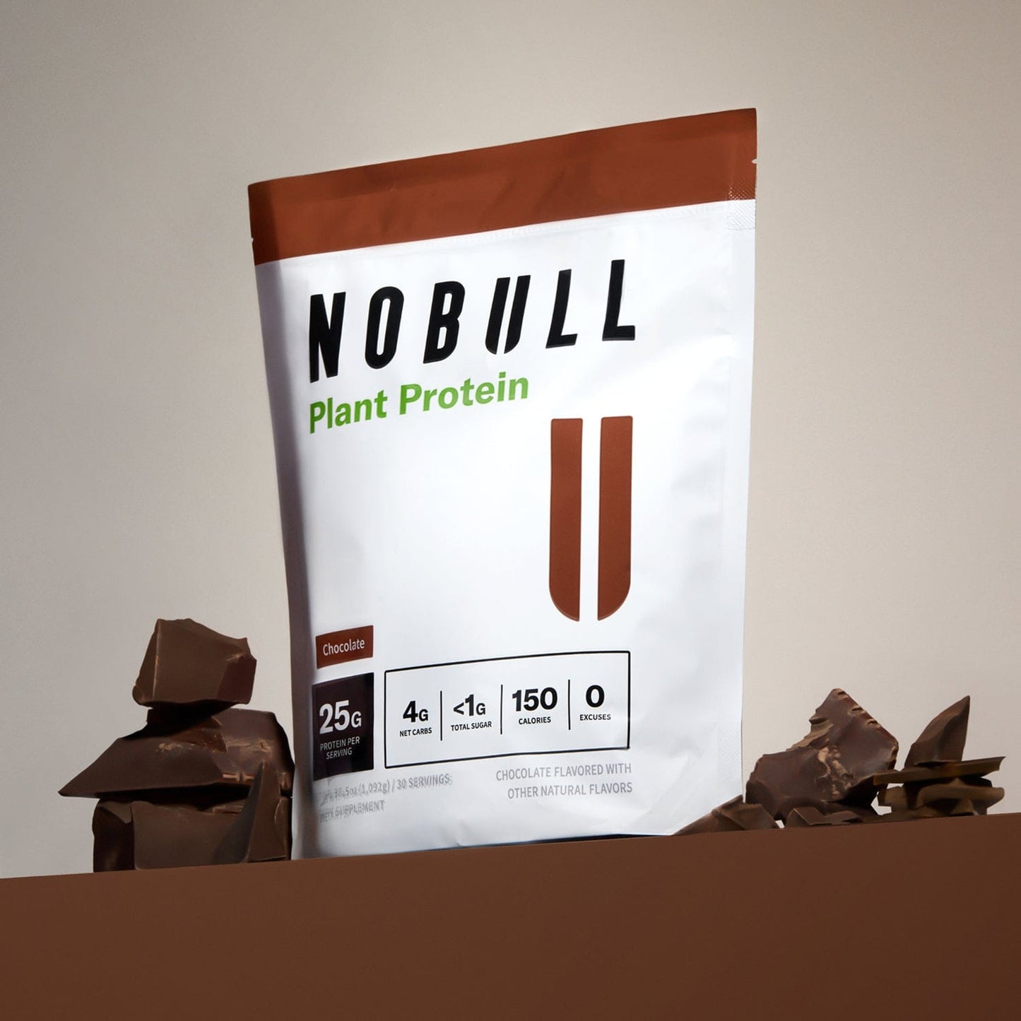 Chocolate NOBULL plant protein package with chocolate pieces on a neutral background