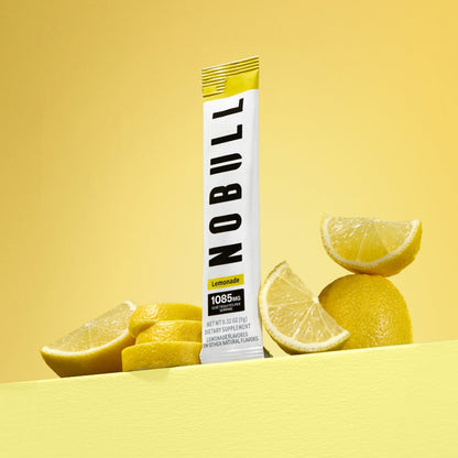 NOBULL lemonade electrolyte stick with lemon slices on a yellow background