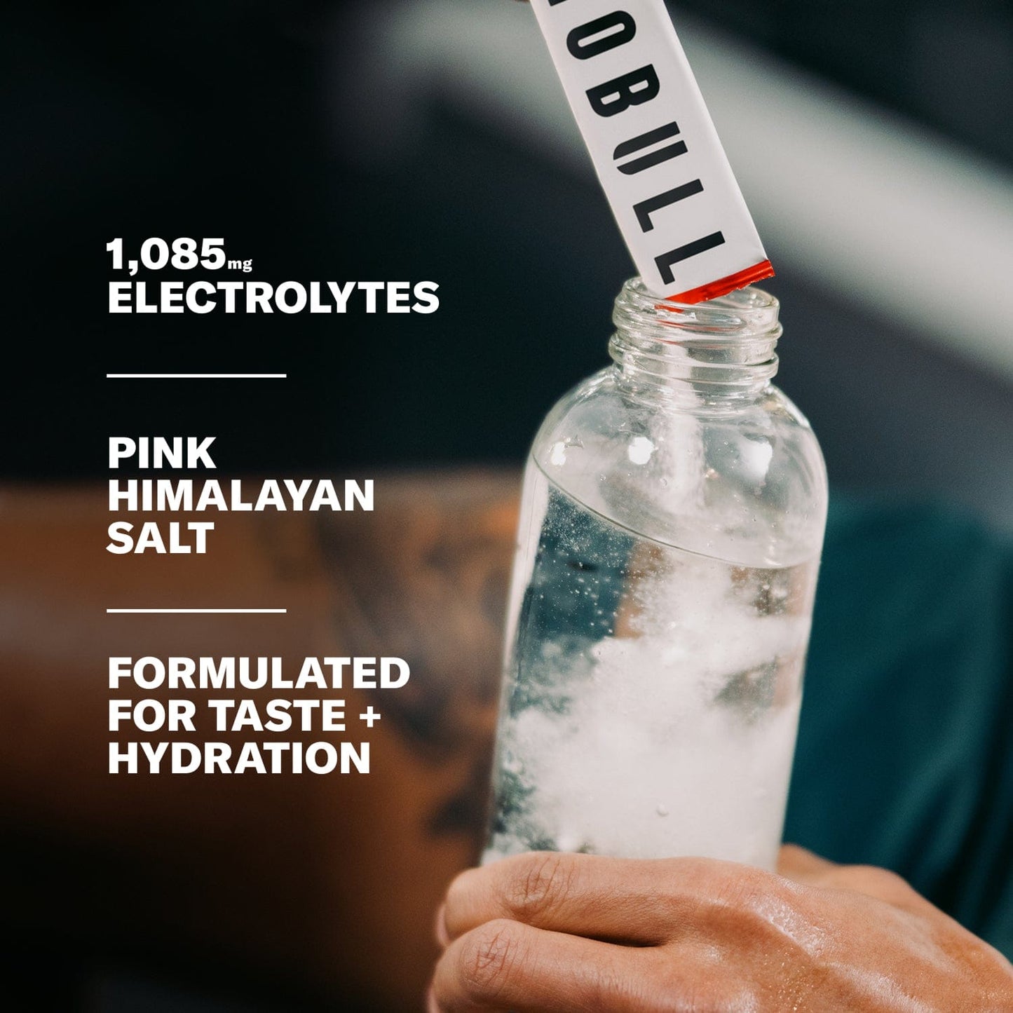 Electrolyte packet being poured into a water bottle.