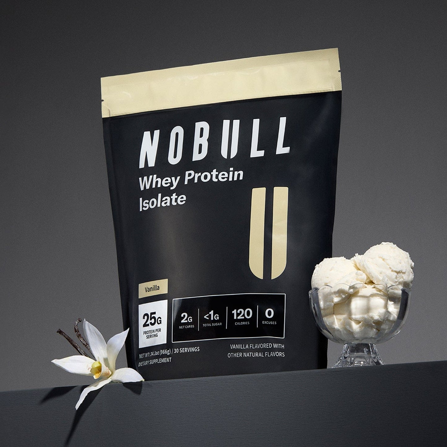 Vanilla NOBULL Whey Protein Isolate package with vanilla flower and protein scoop on a dark background