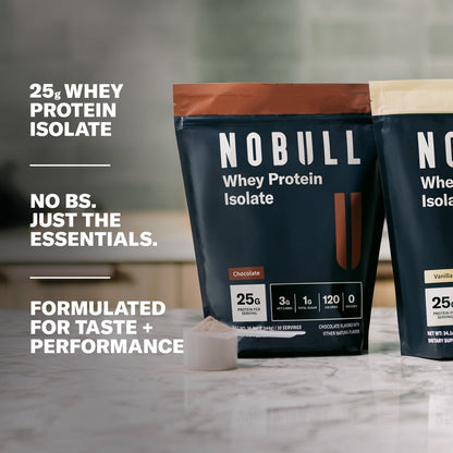 Whey Protein packages on a countertop. Text overlay: 25g Whey Protein Isolate. No BS. Just the essentials. Formulated for Taste and performance