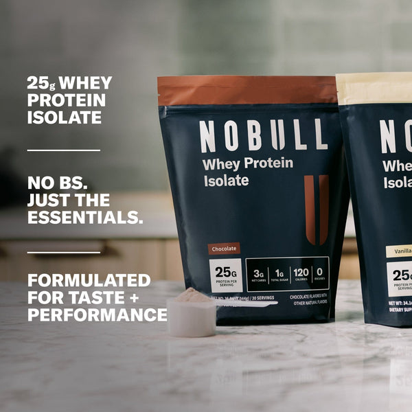 Whey Protein packages on a countertop. Text overlay: 25g Whey Protein Isolate. No BS. Just the essentials. Formulated for Taste and performance