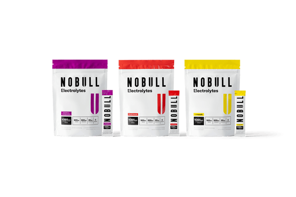 Three NOBULL electrolyte powder packages on a green background