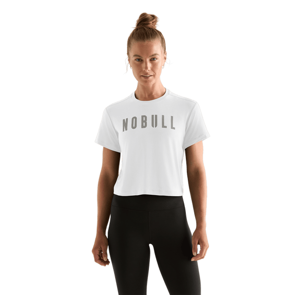 Woman wearing a white 'NOBULL' boxy tee
