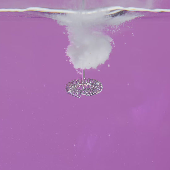 Video of electrolyte powder being mixed in with water on a purple background
