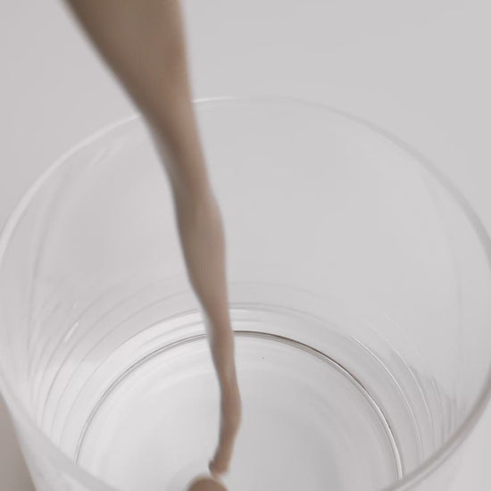 chocolate whey protein shake being poured into a glass